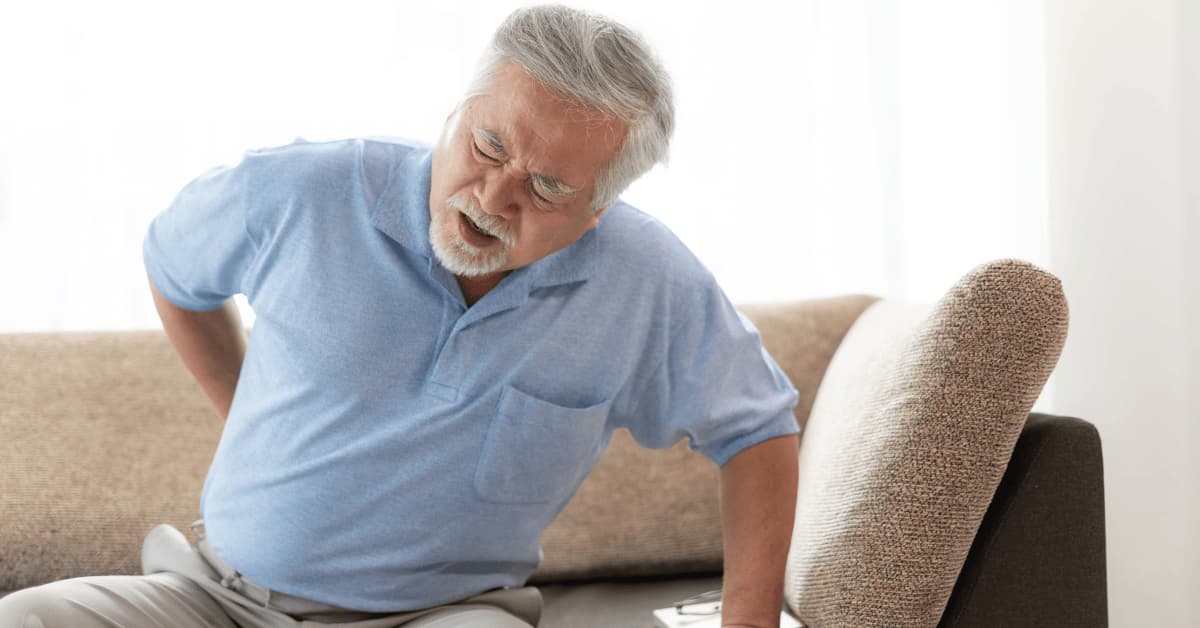 Back pain from bone loss linked to hypothyroidism and osteoporosis Elderly man experiencing back pain due to weak bones caused by hypothyroidism and osteoporosis