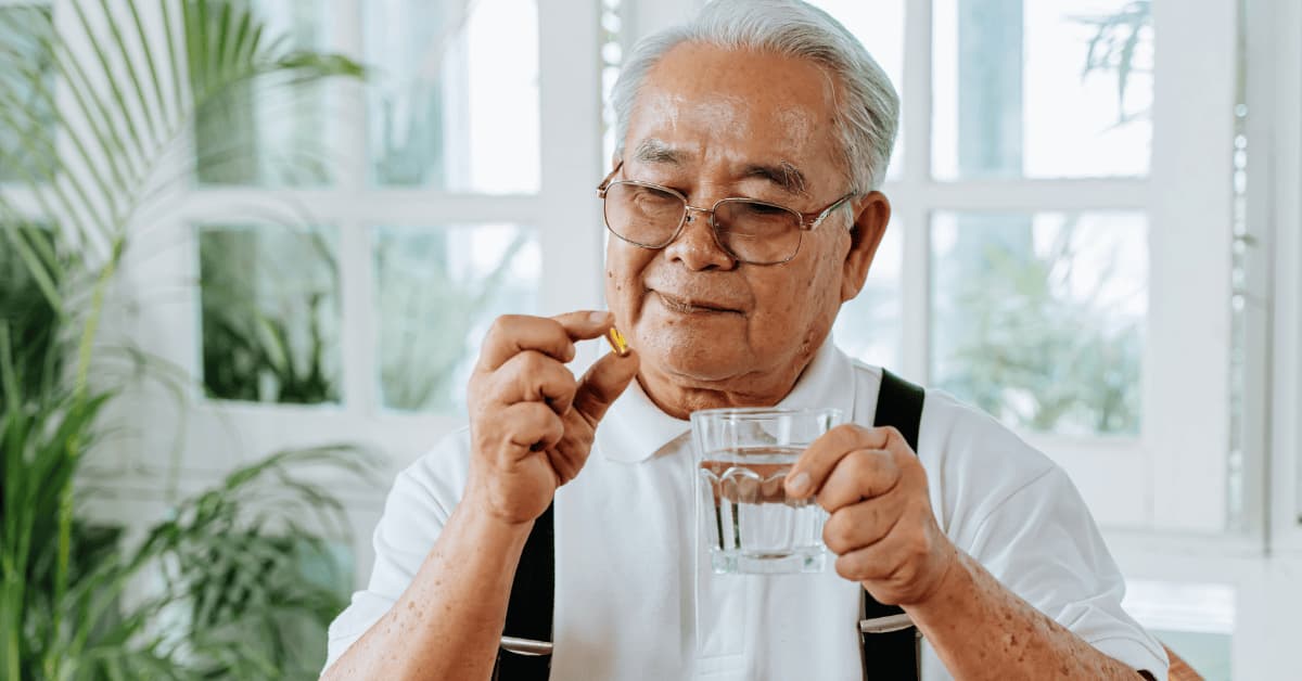 Daily medication and supplement routine for thyroid and bone health management Elderly man taking medication and supplements to manage hypothyroidism and support bone health