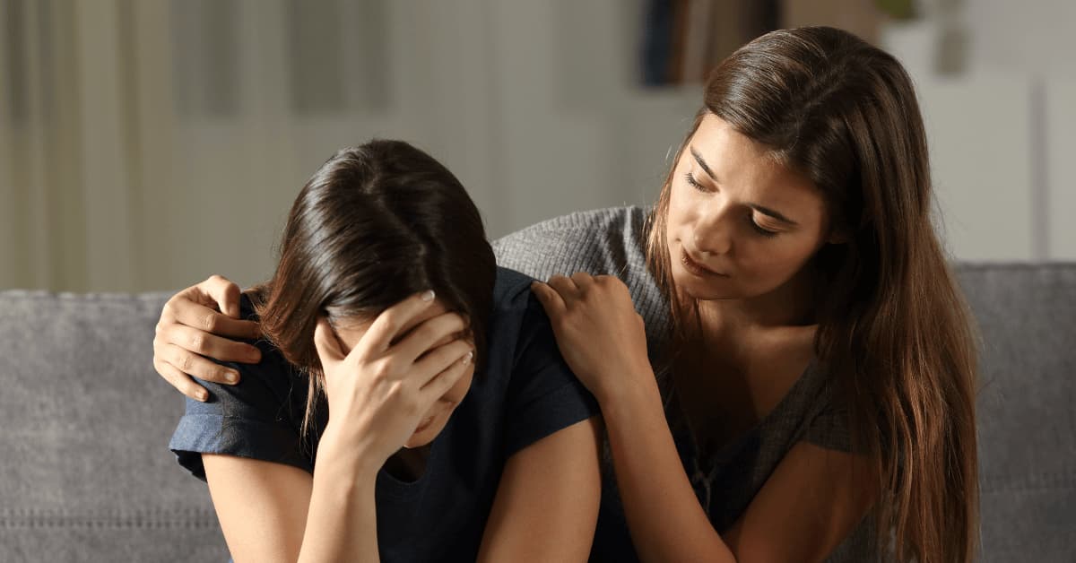 Woman comforting a friend who appears sad and distressed, representing emotional support for someone experiencing depression.