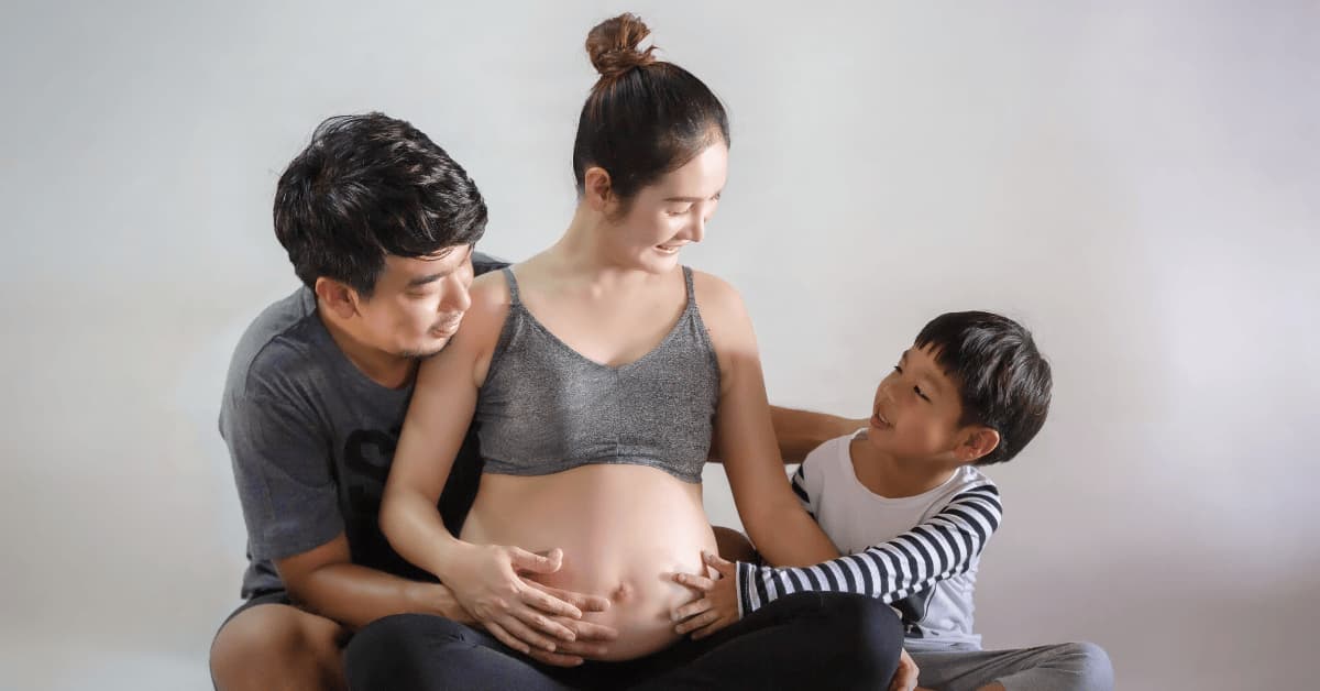 Pregnant mother with her family supporting her during progesterone pills therapy