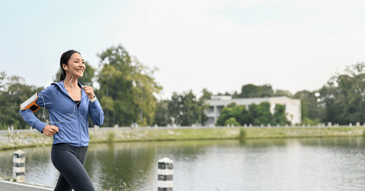 Woman jogging outdoors while using an app for diabetes to support active lifestyle and blood sugar management.