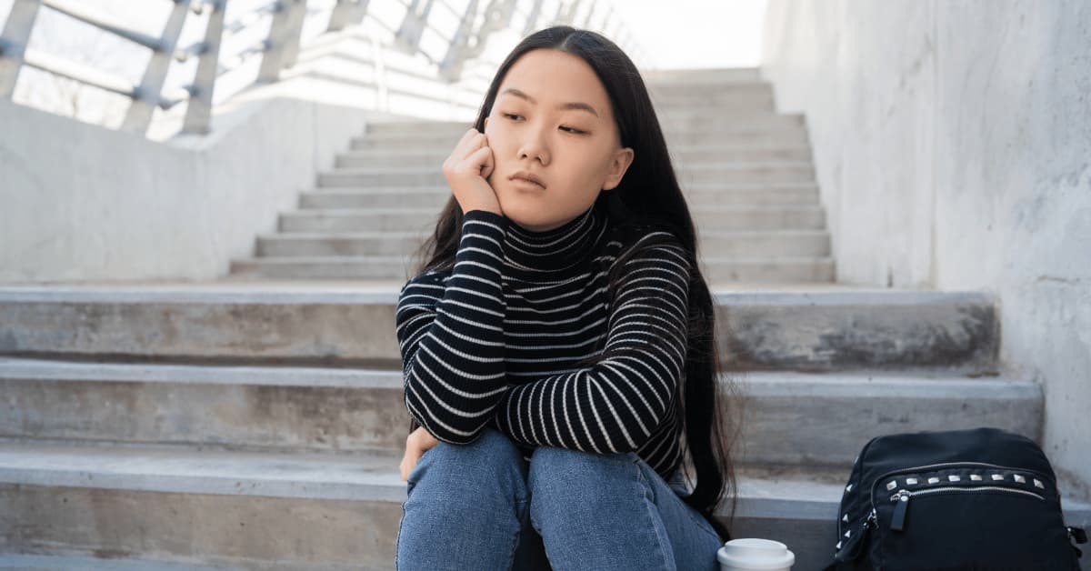 Teen girl sitting alone looking sad, representing mental illness signs and emotional struggles in adolescents